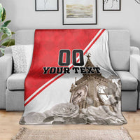 Red and white Big Ben blanket on a sofa, featuring roses and “YOUR TEXT” print