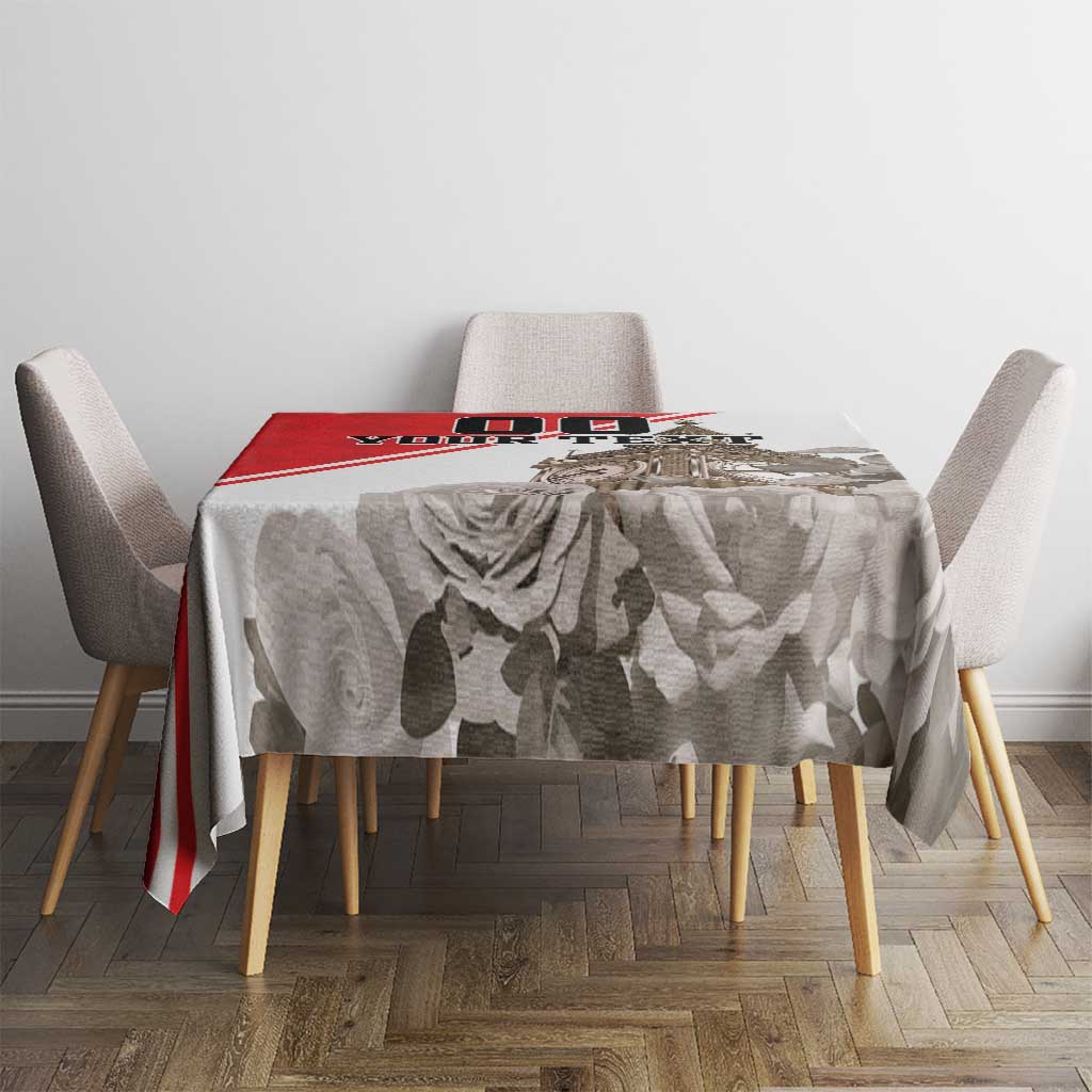 White tablecloth with gray rose and leaf print and red border stripe, top view on table