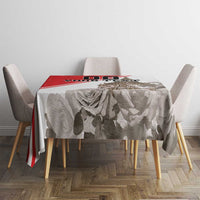 White tablecloth with gray rose and leaf print and red border stripe, top view on table