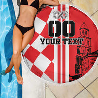 Round red and white beach blanket with checkered center, “YOUR TEXT” lettering, fringe edge