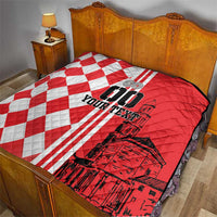 Red and white checkerboard quilt with black city graphic, on a bedspread