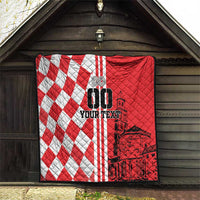 Red and white checkerboard quilt with black city graphic, hanging in a wooden entry