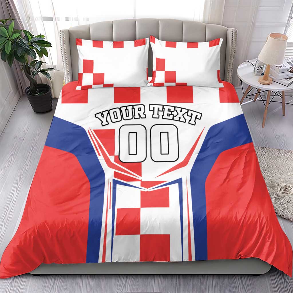 Red, white and blue bedding set with two pillows showing crest graphic and 'YOUR TEXT'.
