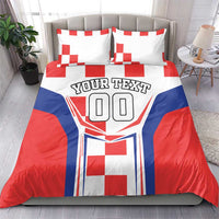 Red, white and blue bedding set with two pillows showing crest graphic and 'YOUR TEXT'.