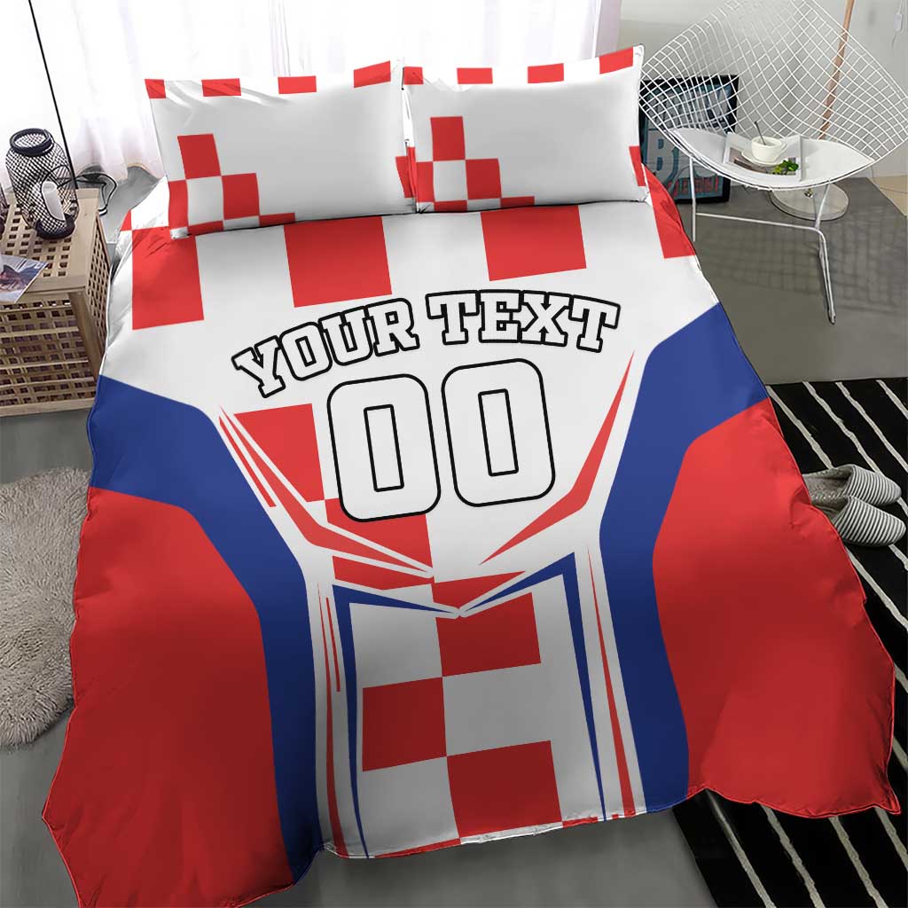 Bedding set in red, white and blue with two pillows, crest graphic and 'YOUR TEXT' text.