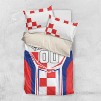 Bedding set on light surface with two pillows; red, white and blue crest and 'YOUR TEXT'.