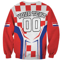 Red and white checkerboard sweatshirt with large “00” graphic and blue flag accents