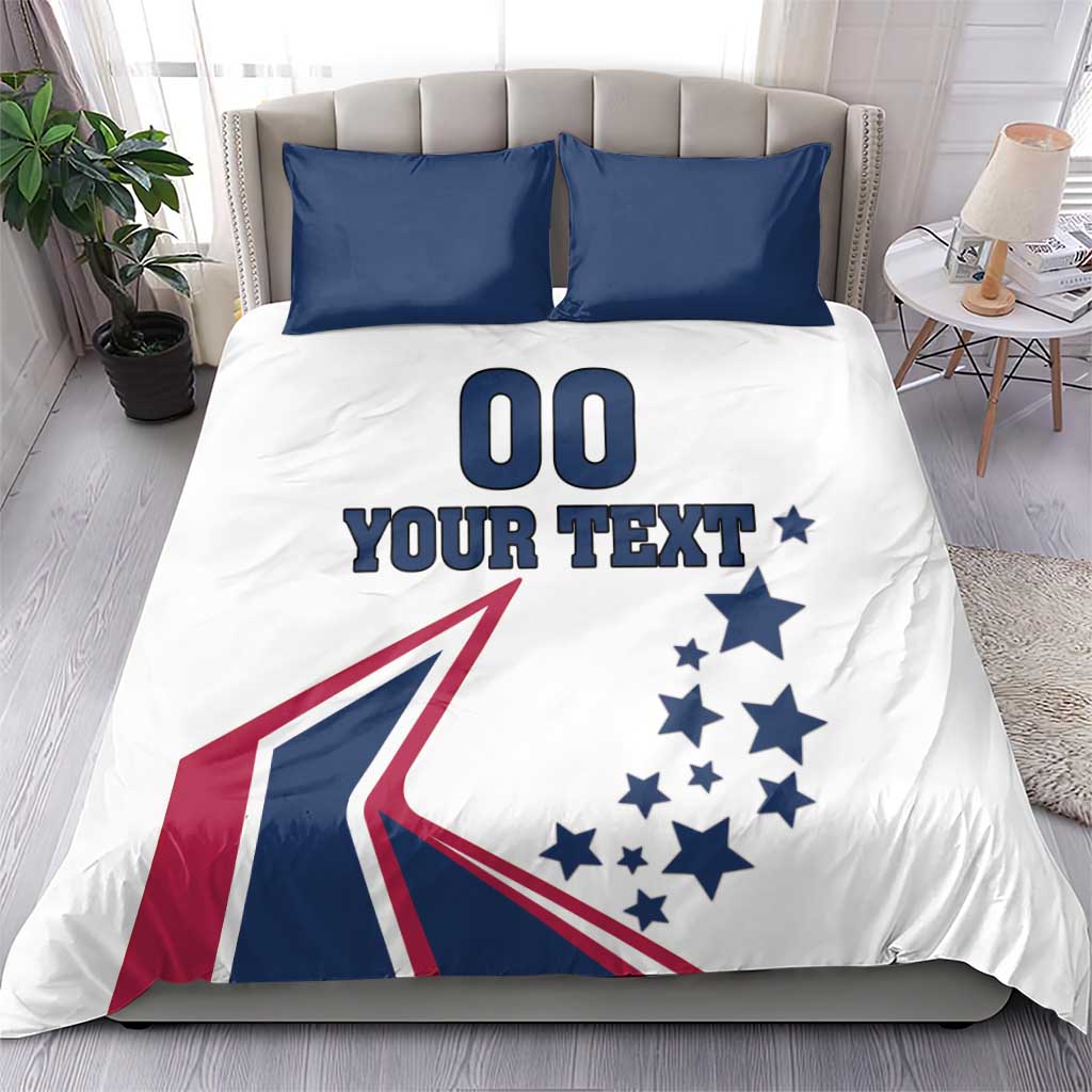 White bedding set with two navy pillowcases; comforter with '00', 'YOUR TEXT', stars, flag graphic