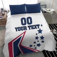 White comforter bedding with two navy pillows; '00' and 'YOUR TEXT' with blue star pattern