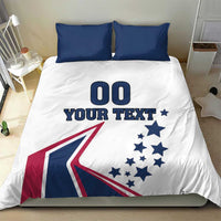 White bedding set with two navy pillowcases; comforter shows '00 YOUR TEXT' and flag graphic