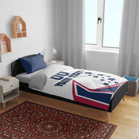 White comforter bedding with two navy pillows; stars and flag graphic with 'YOUR TEXT' on bed
