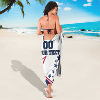 White sarong draped and tied, featuring stars-and-stripes flag graphic on back.