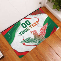 White rubber doormat with “00 YOUR TEXT” and red/green bird wings graphic.