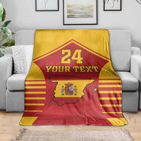 Spain-themed sports blanket draped on a sofa: red/yellow with coat of arms map, 24 and Your Text