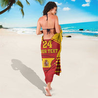 Yellow and red sarong with '24' and 'YOUR TEXT' crest print, tied at waist
