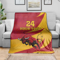 Spain flag-style bull blanket on sofa, red and yellow, "24 YOUR TEXT" print