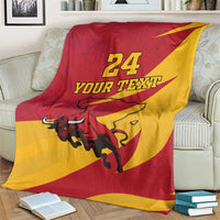 Spain flag-style bull blanket on couch, red and yellow, "24 YOUR TEXT" print