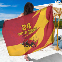 Red and yellow bull graphic sarong with “24 YOUR TEXT” print, draped