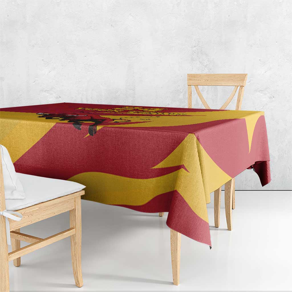 Red, yellow, and maroon bull tablecloth with draped corners on wooden table