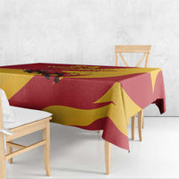 Red, yellow, and maroon bull tablecloth with draped corners on wooden table