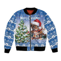Blue bomber jacket with Christmas cat and tree graphic, black ribbed cuffs
