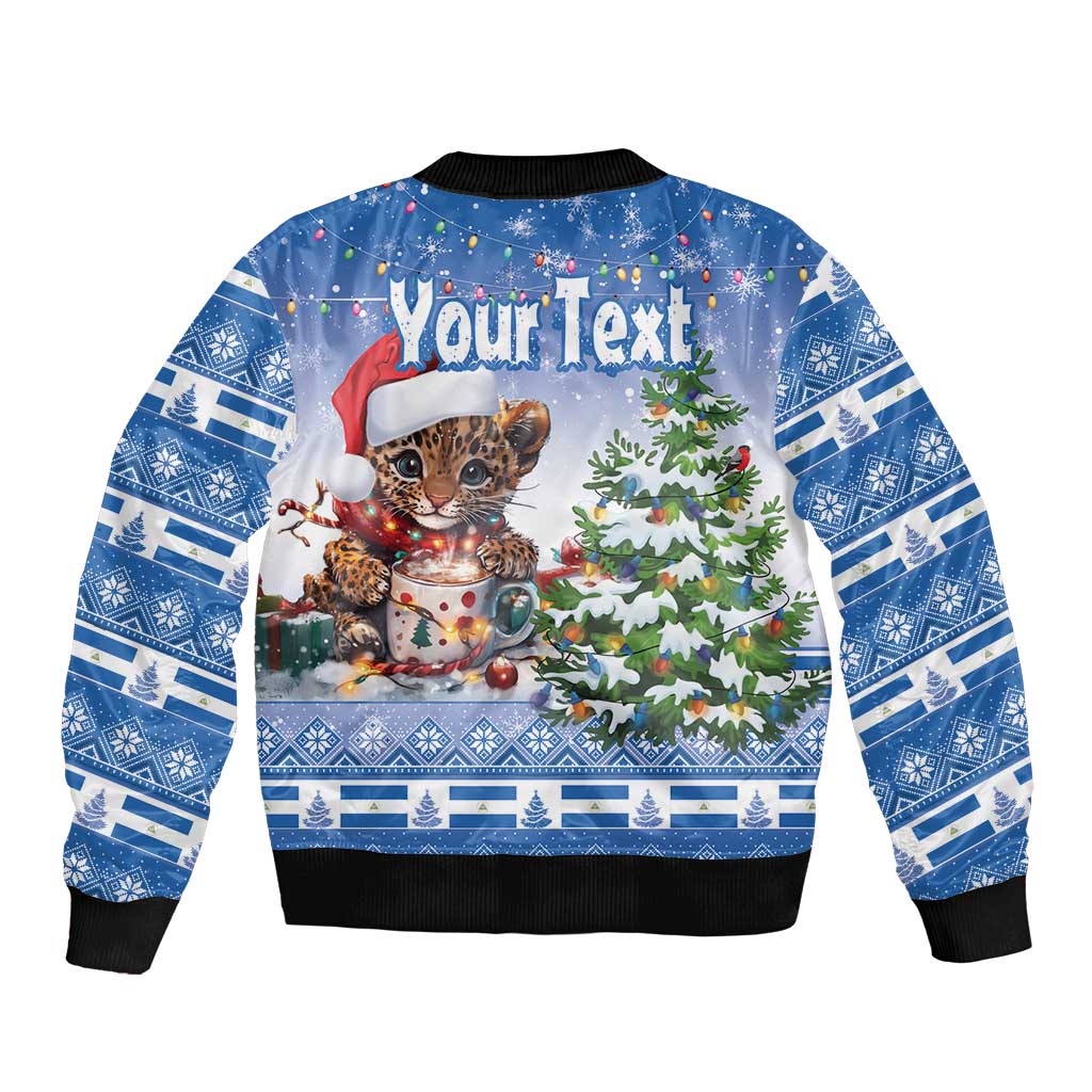 Blue bomber jacket with Christmas cat, snowman and tree graphic, black ribbed hem