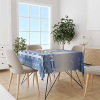 Blue Christmas tablecloth draped over dining table, featuring festive cat and tree design