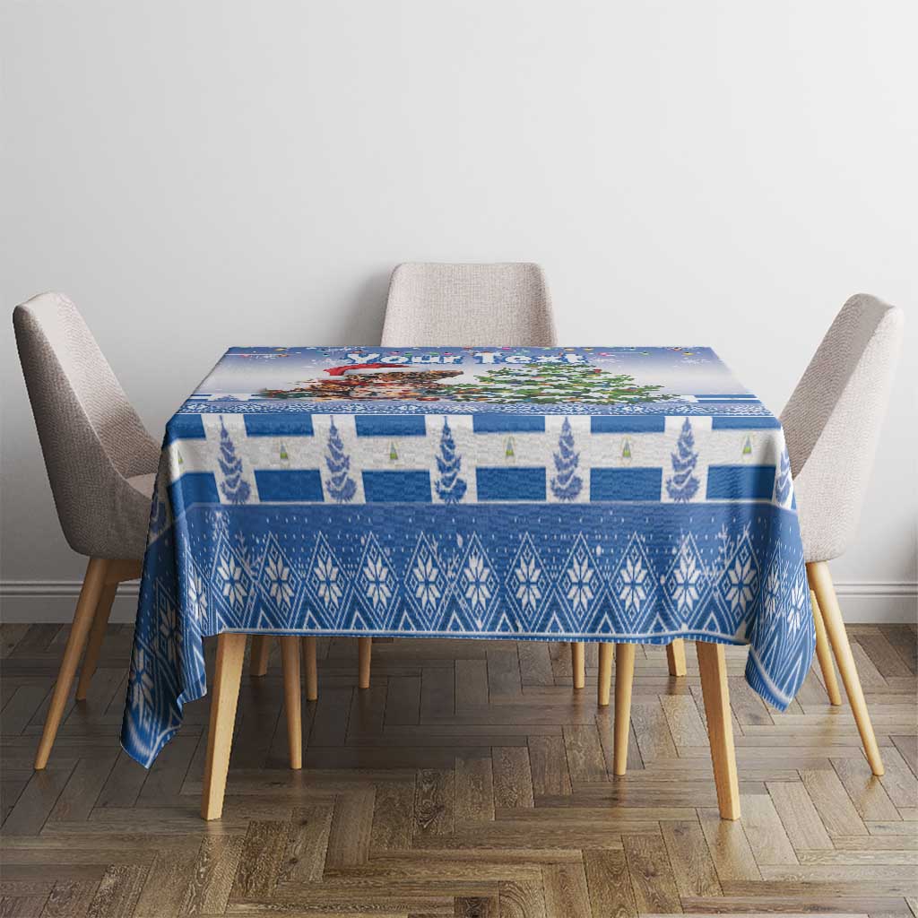 Blue Christmas tablecloth on rectangular table with chairs, featuring cat, tree and winter icons