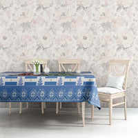 Blue Christmas tablecloth on dining table with festive cat-and-tree graphic and patterned trim