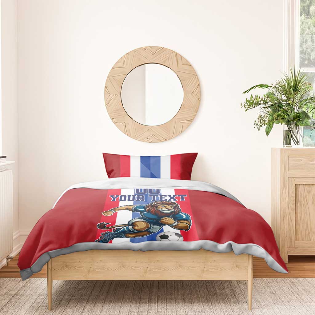 Red football bedding set with lion soccer print, 'YOUR TEXT' and striped pillows on bed.