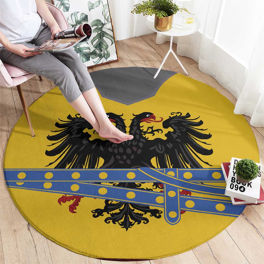 Round yellow rug laid out with black eagle crest and blue decorative stripe