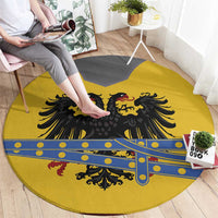 Round yellow rug laid out with black eagle crest and blue decorative stripe
