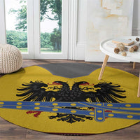 Round yellow rug corner view with black eagle crest and blue decorative stripe