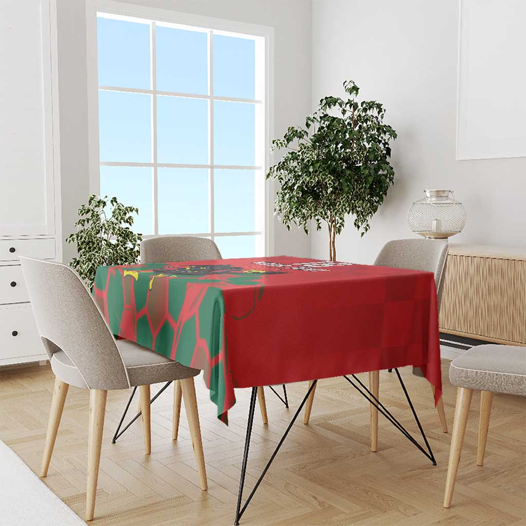 Red tablecloth draped over dining table with green geometric pattern and football design.