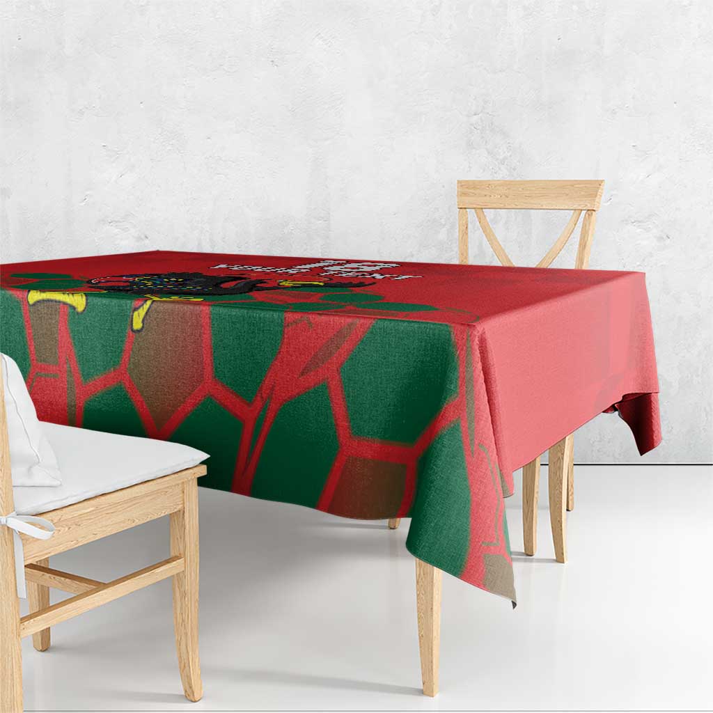 Red and green tablecloth with football-themed graphic, scalloped drape over table edge.