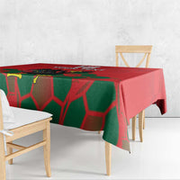 Red and green tablecloth with football-themed graphic, scalloped drape over table edge.