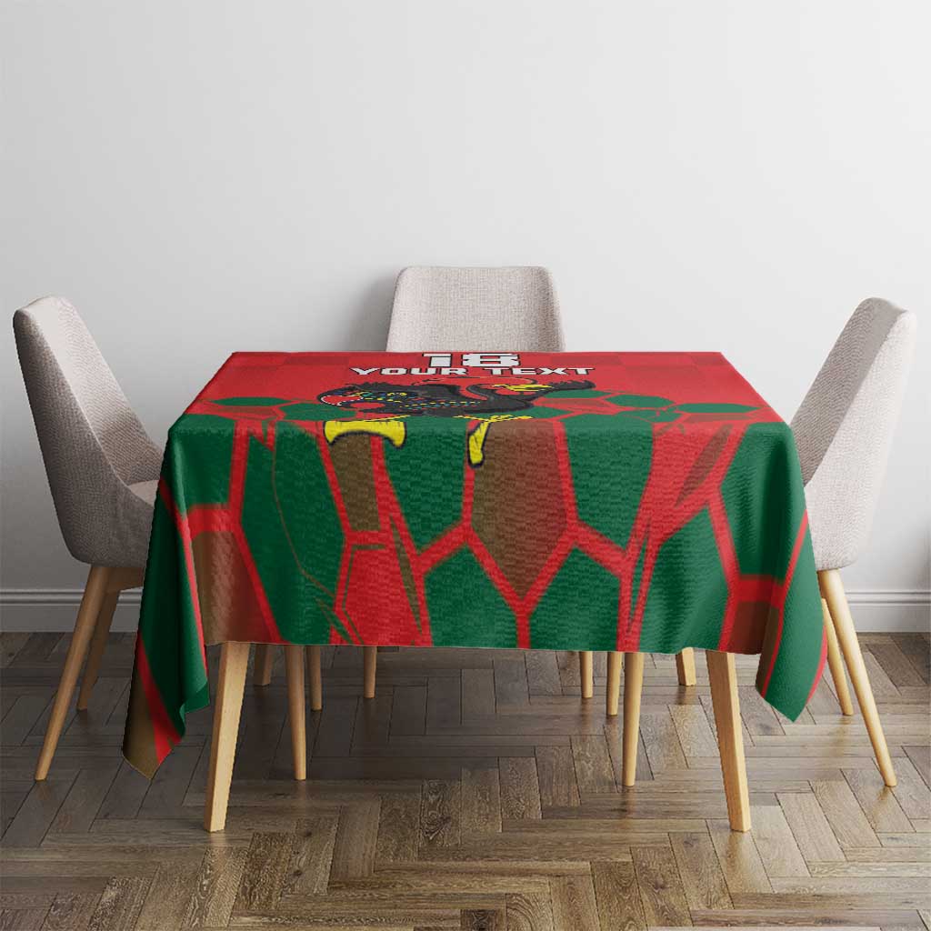 Square dining tablecloth in red with green geometric pattern and rooster mascot, centered view.