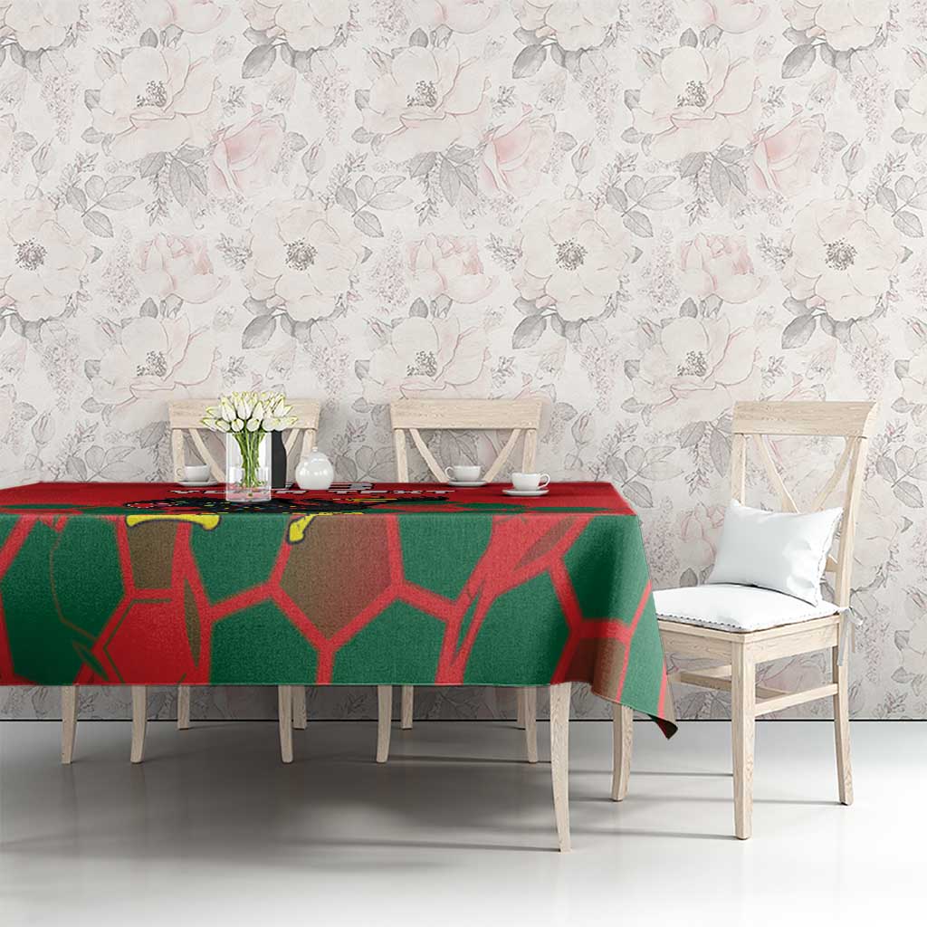 Red tablecloth with green geometric pattern across dining table, rooster graphic near center.