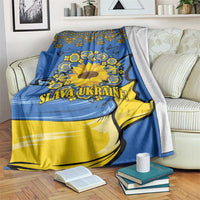 Blue and yellow sunflower folk blanket draped over sofa with bold “SLAVA UKRAINE!”