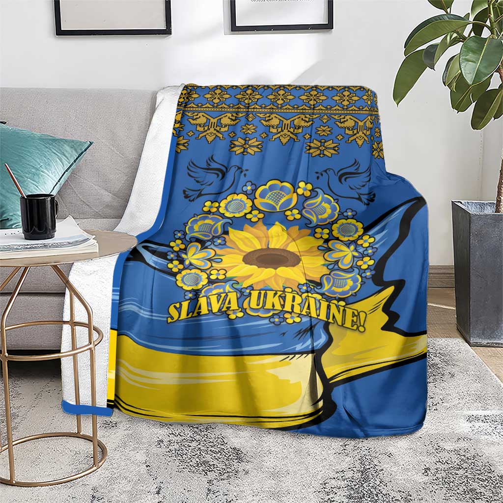 Blue and yellow folk sunflower blanket on floor beside chair, “SLAVA UKRAINE!”