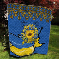 Blue quilt with gold folk pattern border, sunflower peace sign and dove silhouette