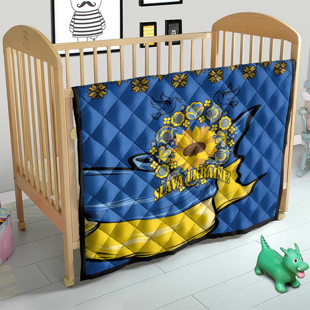 Blue quilt on a toddler bed frame with yellow band, folk border, sunflower peace sign