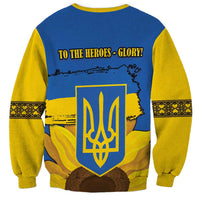 Back blue sweatshirt with yellow sleeves, trident emblem, sunflower scene, TO THE HEROES text