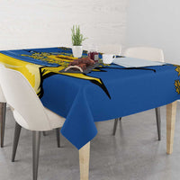 Blue tablecloth on dining table with yellow trident and sunflower folk motif across corner