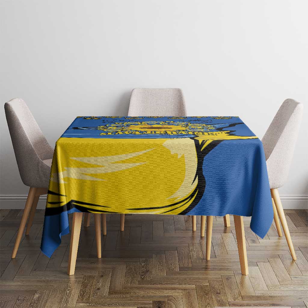 Blue tablecloth with yellow trident and sunflower folk pattern covering dining table center