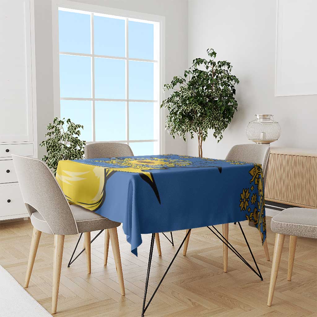 Blue tablecloth on dining set with yellow trident and sunflower folk motif along table edge