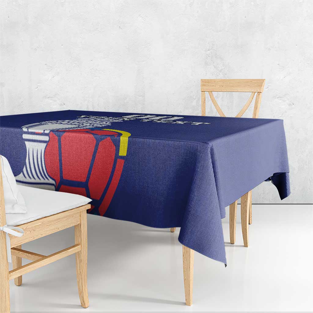 Blue football tablecloth draped over rectangular table with cup and football artwork