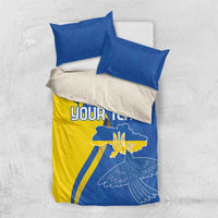 Blue and yellow bedding set with two pillowcases, 'YOUR TEXT' and dove crest