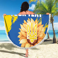 Round beach blanket, held up, yellow-and-blue sunflower trident graphic with fringe trim