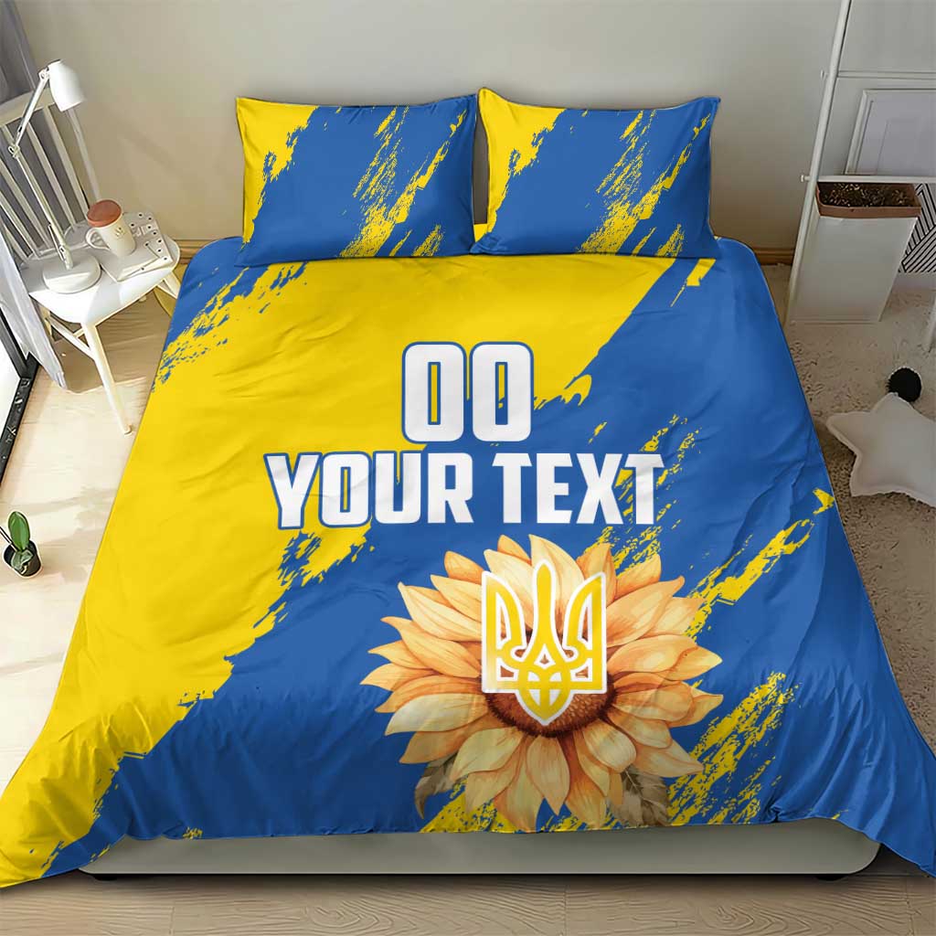 Blue and yellow duvet cover set with two pillows, 'YOUR TEXT' and flower emblem centerpiece